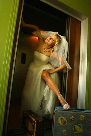 The beautiful bride in the lift with two suitcasesの写真素材