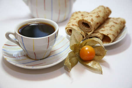 A cup of coffee with pancakes on tableの写真素材