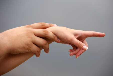 Man's and female hand on a background of the skyの写真素材