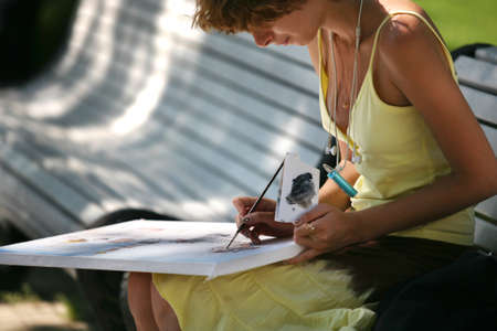 The girl draws a picture in parkの写真素材