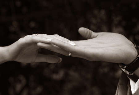 Female hands in man's hands on a dark background. b/w+sepiaの写真素材