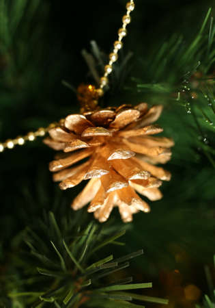 Gold pine cones on a chain on a fur-treeの写真素材