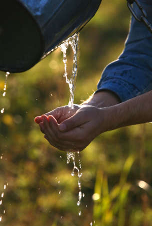 The man washes hands with transparent waterの写真素材