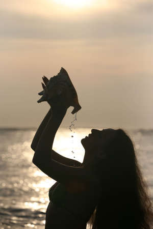 Silhouette of the beautiful girl with a cockleshellの写真素材