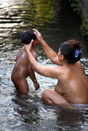 Mother bathes the child in the river. Indonesia. Baliの写真素材