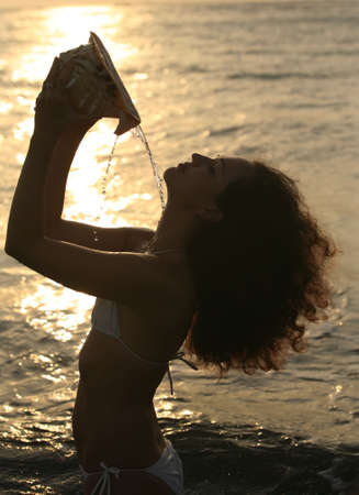 Silhouette of the beautiful girl with a cockleshellの写真素材