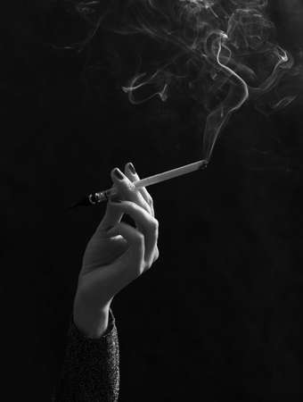 Hand with a cigarette with a smokeの写真素材