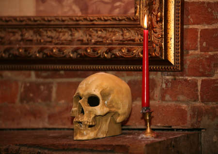 Human skull and candle in an interiorの写真素材