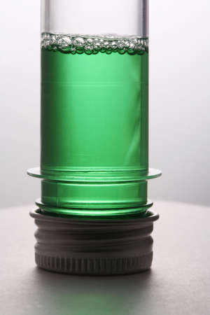 Test tube with a green liquid on a white backgroundの写真素材