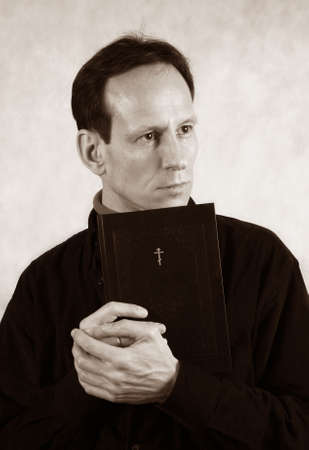 Thoughtful the man with the bible on a light background