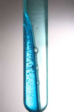 Test tube with a dark blue liquid on a white backgroundの写真素材