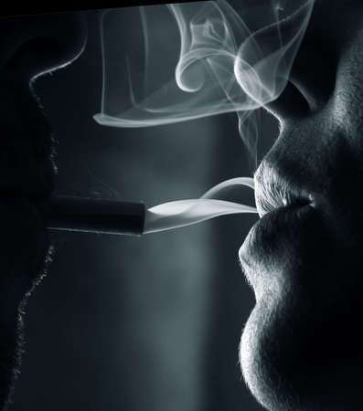 Two silhouettes of smoking people close-upの写真素材
