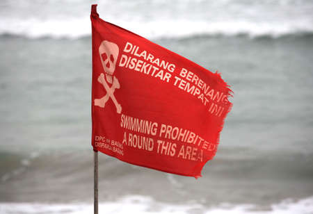 Swimming prohibited around this area flag in Kuta beach Baliの写真素材
