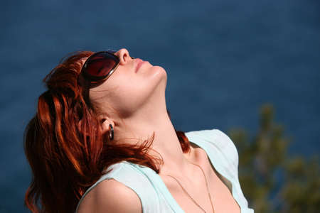 The woman with red hair enjoys the sunの写真素材