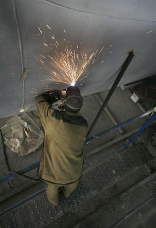 Worker welding metal and sparks spreading