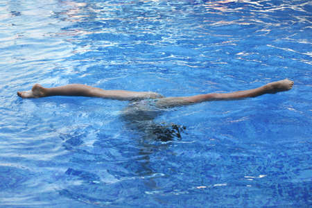 Legs of the sportsman in blue water の写真素材