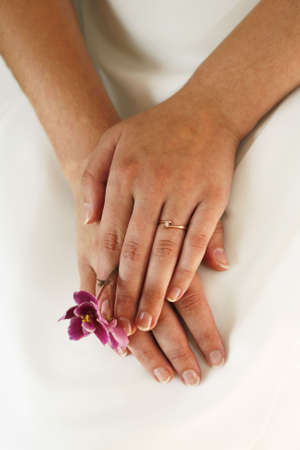 Hands of the bride on a background of a wedding dressの写真素材