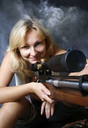 The girl with a gun in studioの写真素材