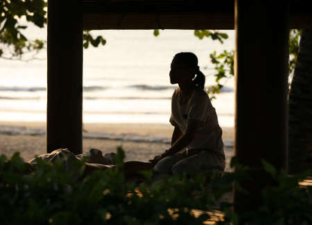 The girl-masseur in Bali salon on sunsetの写真素材