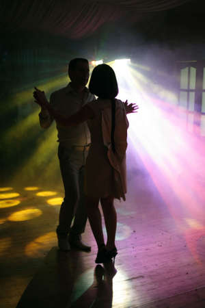 Dancing pair on a background of rays of light