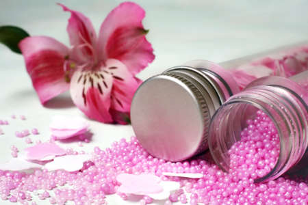 Bottles with pink salt for baths and flowerの写真素材