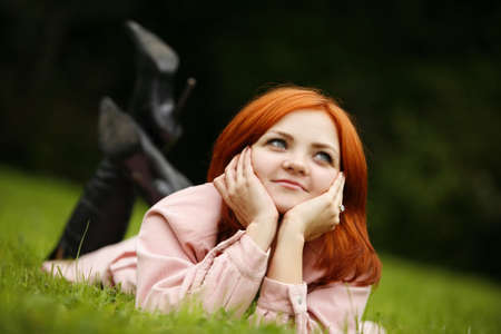 Portrait of the girl with red hair in a grassの写真素材
