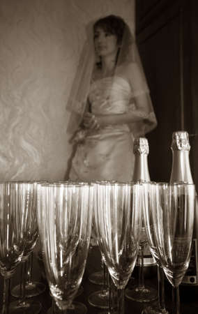 The worrying bride pending the groom on a background of glassesの写真素材