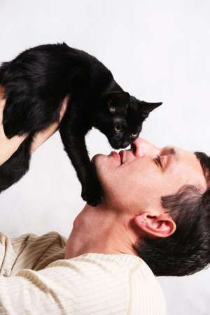 Man covers a kitten on a white backgroundの写真素材