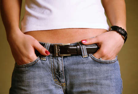 Young woman in blue jeans shorts with a leather beltの写真素材