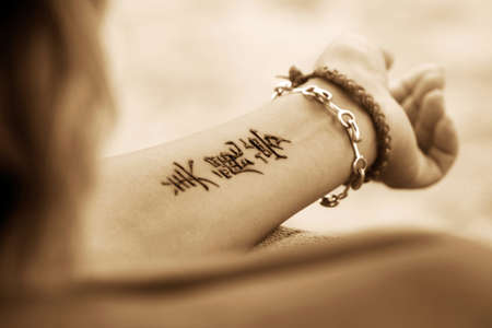 A woman's hands with a beautiful henna tattoo. Hieroglyph 