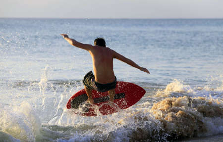 Young men - the surfer in ocean. Bali. Indonesiaの写真素材