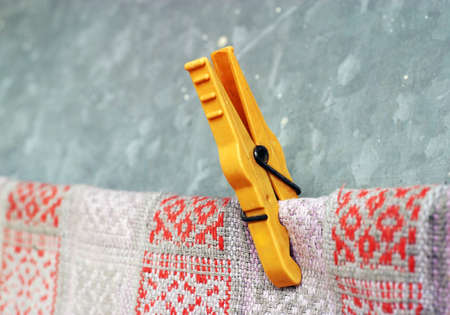 Old yellow clothespin holding a doormatの写真素材