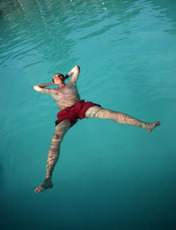 Man enjoying summer in the poolの写真素材