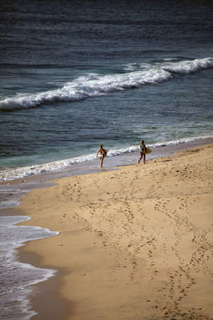 Two girls with boards for surfing at coast of the Indian ocean. Dreamland beach - Baliの写真素材