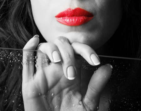 Beautiful female lips and hand with wet glassの写真素材