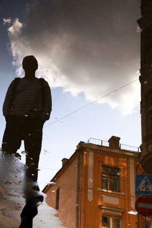 Reflection of a building, clouds and men in waterの写真素材