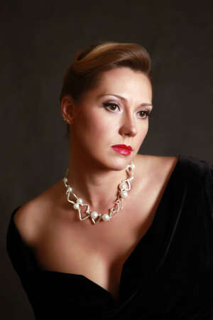 Portrait of the beautiful woman in a pearl necklace in studio
