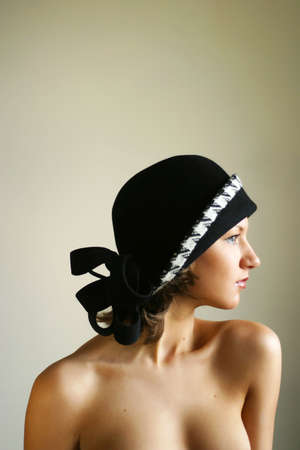 The beautiful girl in a hat in studio