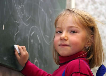 The little girl on a background of a school boardの写真素材