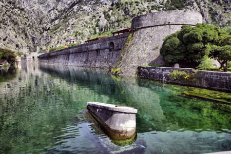 Old wall at the river on a background of mountains. Kotor. Montenegroの写真素材