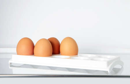 Four brown eggs in cells on a grey backgroundの写真素材