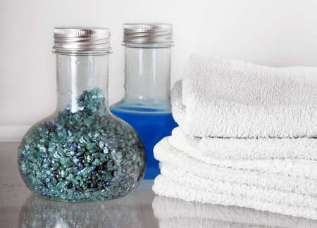 White towels and two bottles with shampoo and salt for bathsの写真素材
