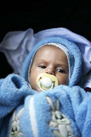 The young child in a blue suit on a dark background