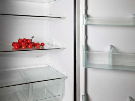 Empty refrigerator with fresh tomatosの写真素材
