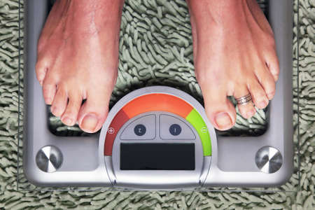 Bathroom scales isolated against green carpet