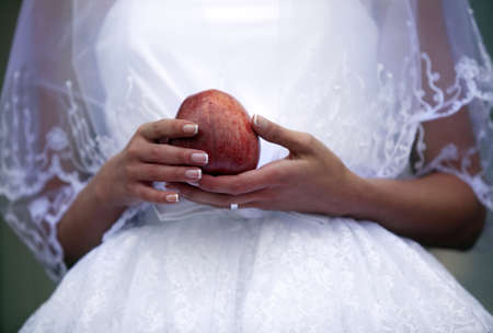 Red apple in hands of the brideの写真素材