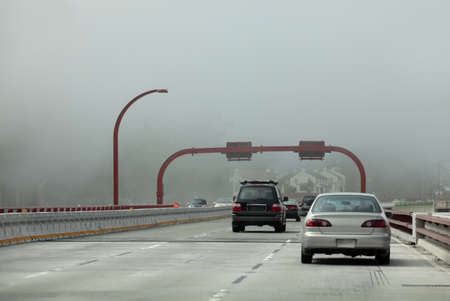 Departure of automobiles the bridge in foggy day. San Franciscoのeditorial素材