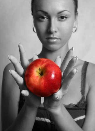 The girl holds in hands red an apple  Partial decolourationの写真素材