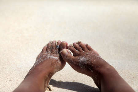 Female barefooted legs soiled in sandの写真素材