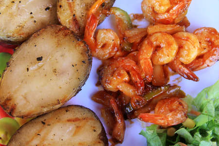 prawn in sweet red sauce with a potato and vegetablesの写真素材